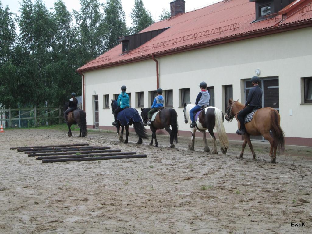 a group of people riding horses in front of a building at Centrum Turystyczno- Rehabilitacyjne in Krzyżewo
