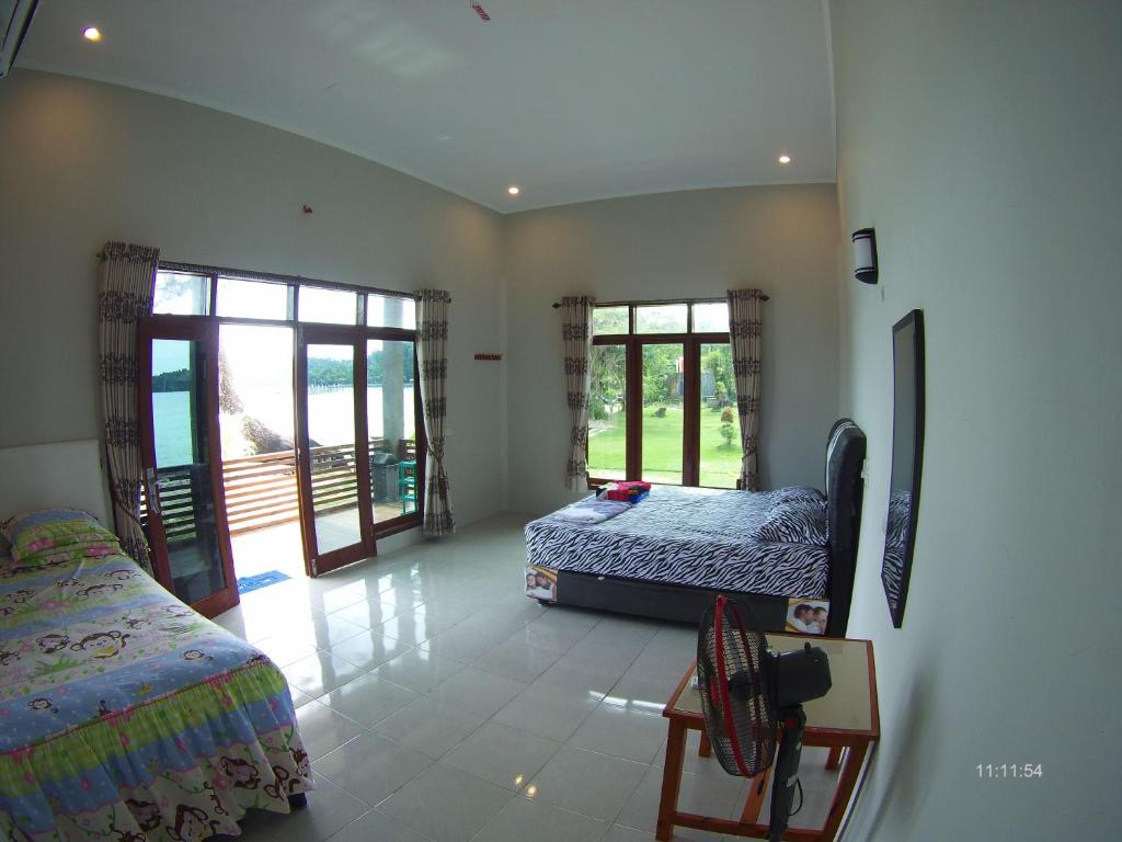 a bedroom with two beds and two windows at Panorama Seulako in Sabong