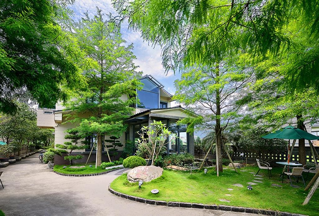 una casa con un jardín delante de ella en Pokara Resort en Jiaoxi