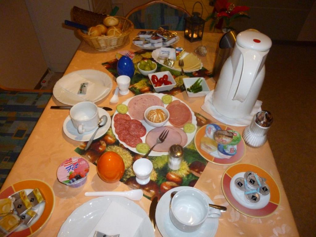 a table with plates and food on it at Pension am Peeneufer UG in Wolgast