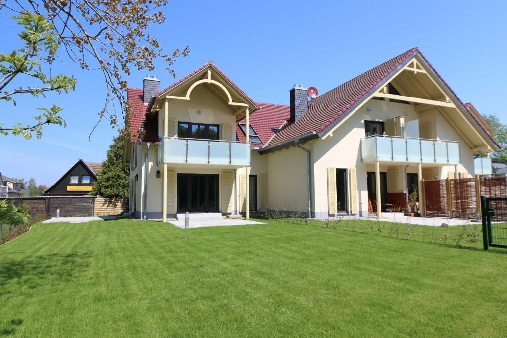 a house with a lawn in front of it at Haus Sterntaucher - Ferienwohnung 06 mit Balkon in Thiessow