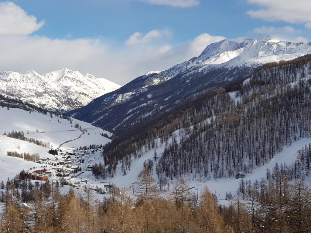 śnieżne pasmo górskie z wioską na śniegu w obiekcie Monolocale Milky Way - Sestriere w mieście Sestriere