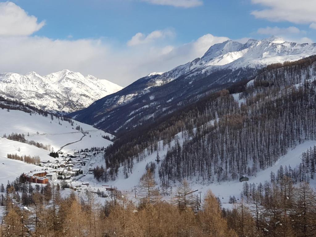 a snowy mountain range with a village in the snow at Monolocale Milky Way - Sestriere in Sestriere