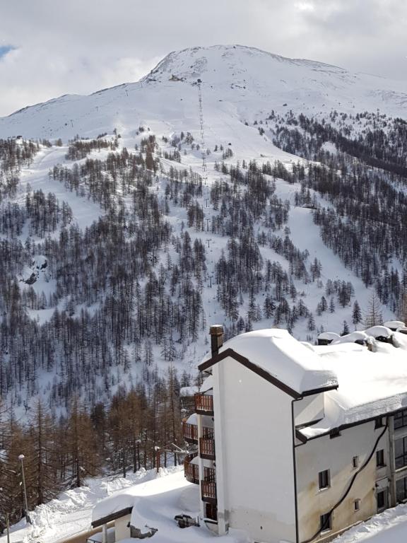 budynek w śniegu z górą w tle w obiekcie Monolocale Milky Way - Sestriere w mieście Sestriere