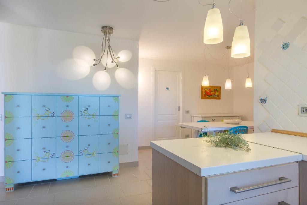 Il comprend une cuisine dotée d'un mur carrelé bleu et blanc. dans l'établissement Villa Ginestra con piscina e giardino privato a 500 mt dal mare, à Castiadas