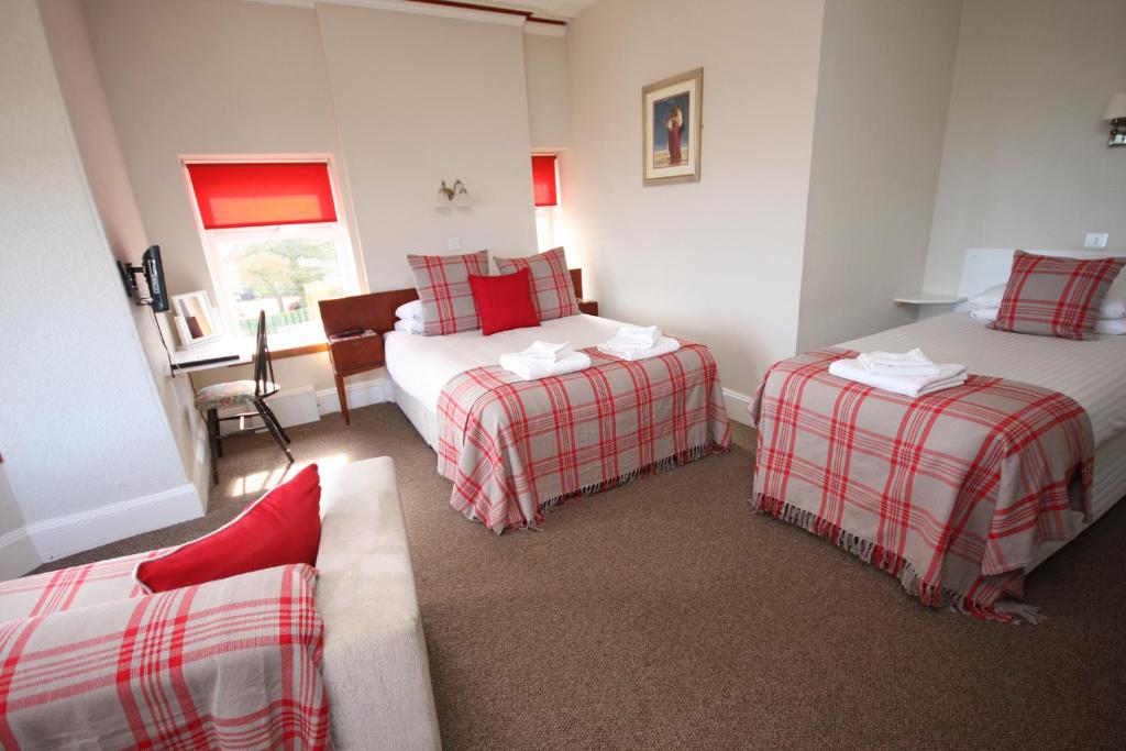 a hotel room with two beds and a couch at St Olaf Golf Hotel in Cruden Bay