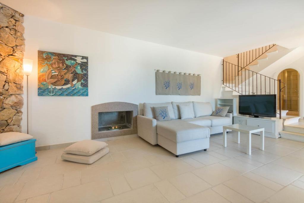 un salon avec un canapé et une cheminée dans l'établissement Villa Ginestra con piscina e giardino privato a 500 mt dal mare, à Castiadas