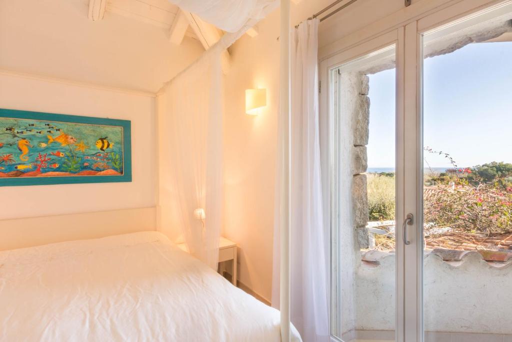 une chambre avec un lit et une fenêtre dans l'établissement Villa Ginestra con piscina e giardino privato a 500 mt dal mare, à Castiadas 32 autres photos