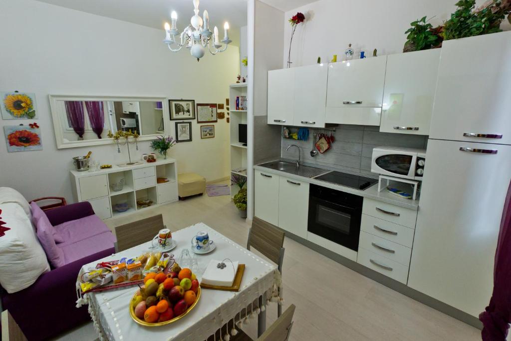 una cocina con armarios blancos y una mesa con fruta. en Casa in Centro!House in City Center!, en Bolonia