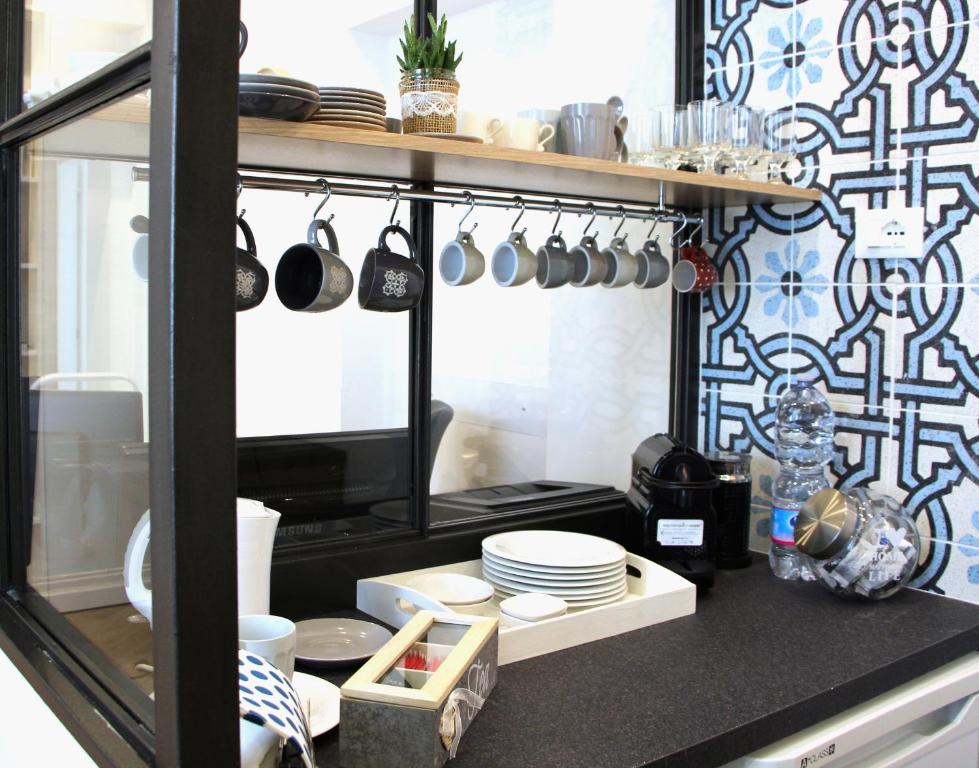 a kitchen with plates and utensils on a counter at B&B Vivere Palermo in Palermo