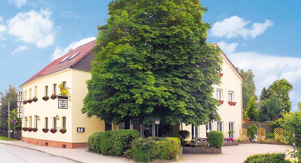 a large tree in front of a building at Hotel & Gasthof Zum Löwen in Eisenach