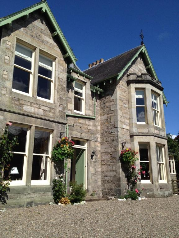 a large stone house with a green door at Willows Bed & Breakfast in Pitlochry