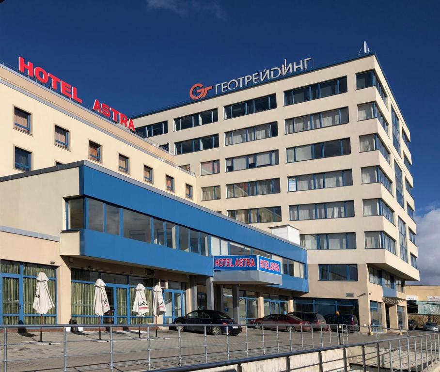 un bâtiment d'hôtel avec des parasols en face de celui-ci dans l'établissement Hotel Astra, à Sofia