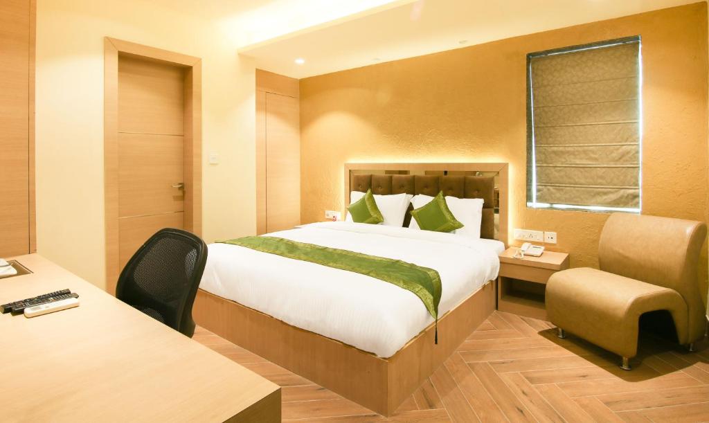 a hotel room with a bed and a desk at Treebo Trend Hoops - Airport in Kolkata