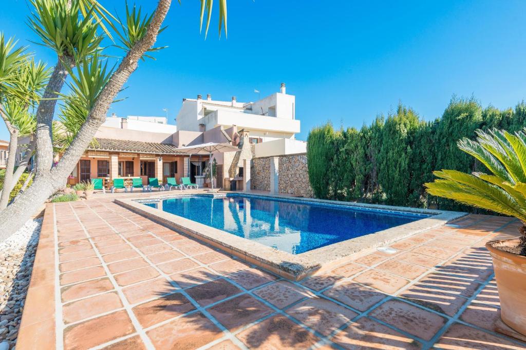 una piscina frente a una casa con palmeras en Buenos Aires, en Manacor