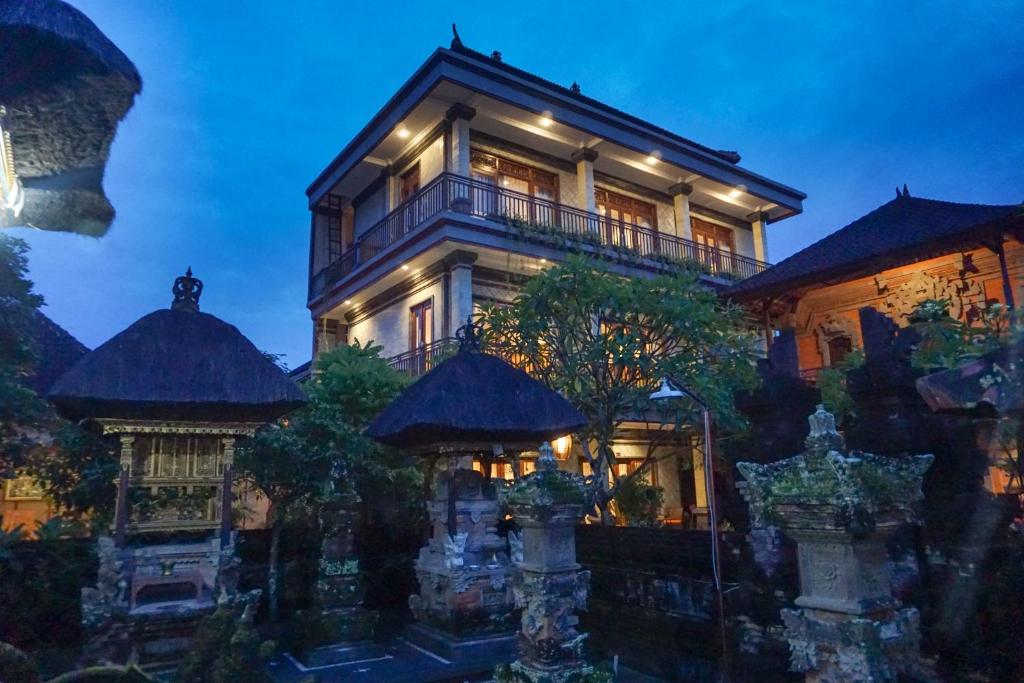 ein großes Haus mit einem Gebäude davor in der Unterkunft Three Brothers Guest House in Ubud