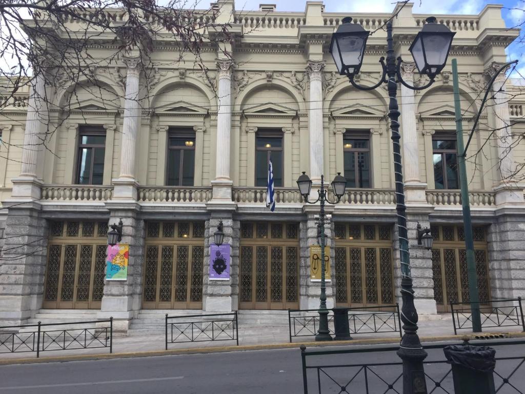 budynek z dwoma flagami przed nim w obiekcie ATHENS Central BEAUTIFUL APARTMENT!!! w Atenach