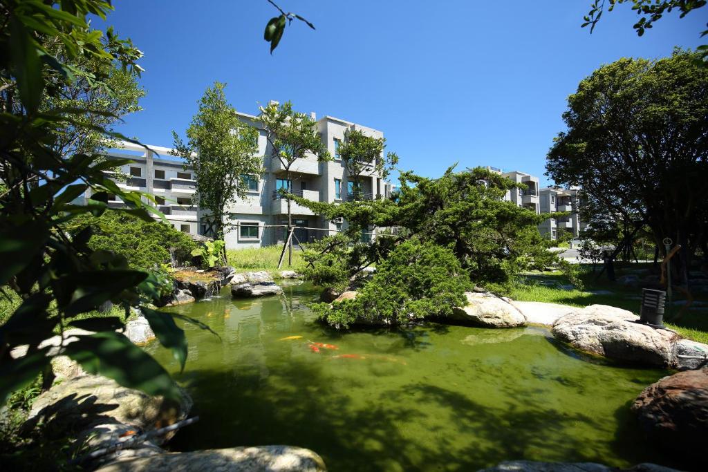 a pond in a park with a building in the background at 三匠獨棟庭園別墅 1烤肉打牌 2聰明包棟-依人數提供床位及房間數 3寵物友善 4近夜市 in Ji'an