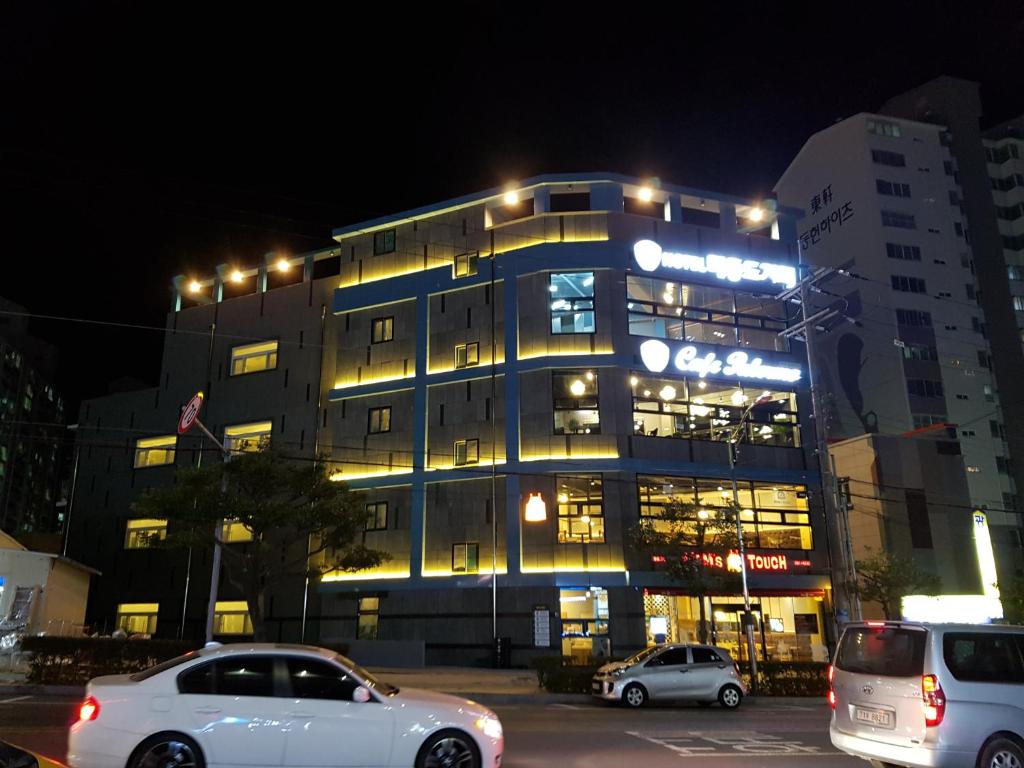 a white car parked in front of a building at night at Maison de Geoje in Geoje 