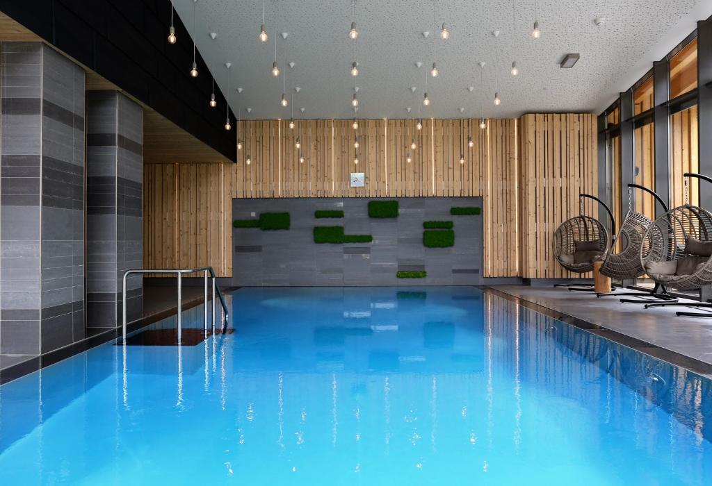 a swimming pool with blue water in a building at Villa Silva - Oberhof in Oberhof