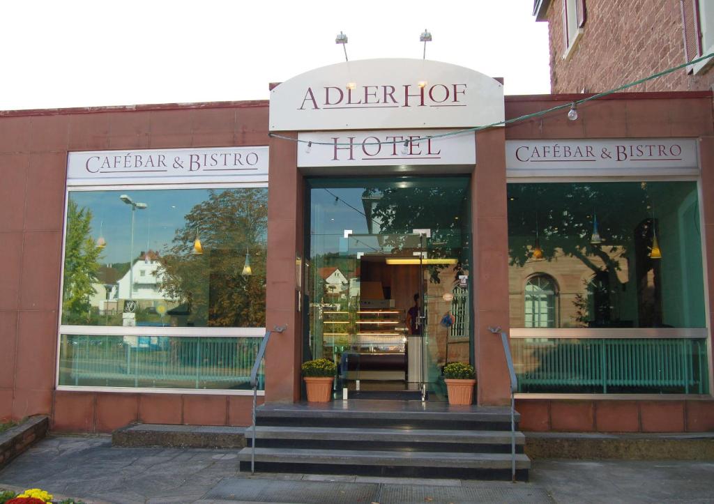 ein Geschäft vor einem Hotel mit Treppe davor in der Unterkunft Hotel Adlerhof in Tauberbischofsheim