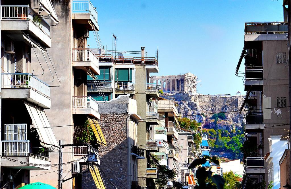 Urban Art Experience with Acropolis View في أثينا: مجموعة مباني فيها جبل في الخلف