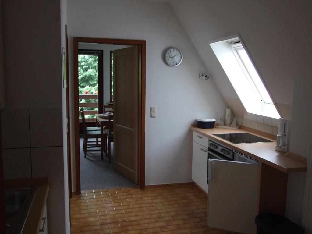 uma cozinha com um lavatório e um relógio na parede em Ferienwohnung Emmi em Malente