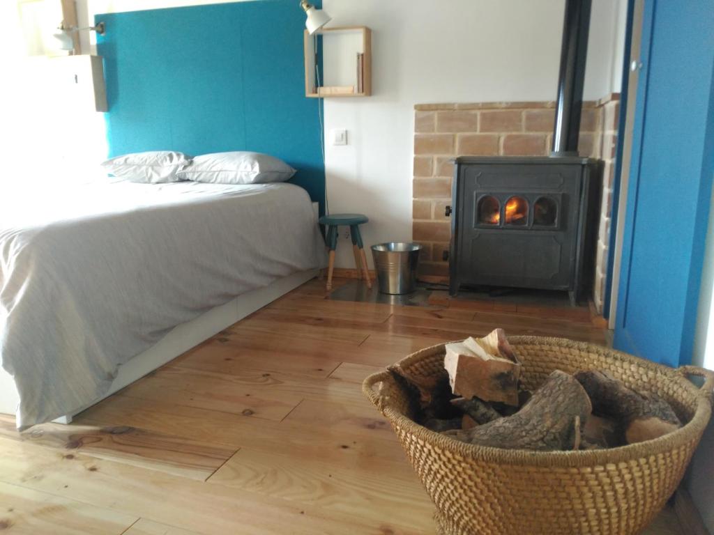 a bedroom with a bed and a basket with a fireplace at El Pretil del Olmo in Cuenca