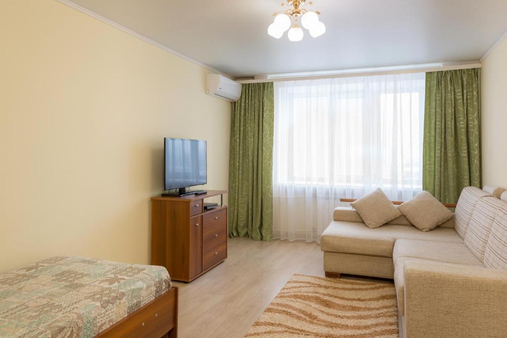 ハバロフスクにあるАпартаменты на Серышева 80のリビングルーム(ソファ、テレビ付)
