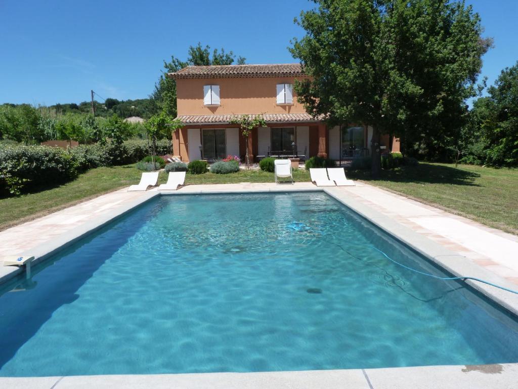 a swimming pool in front of a house at La Bastide des Vignaux in Grimaud