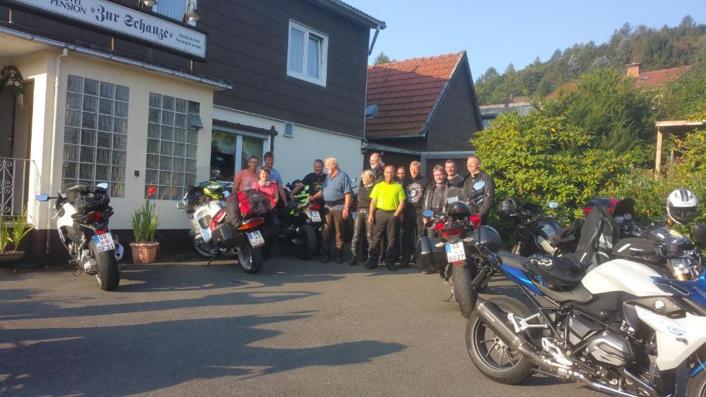 a group of people standing in front of a group of motorcycles at Hotel Zur Schanze in Wieda