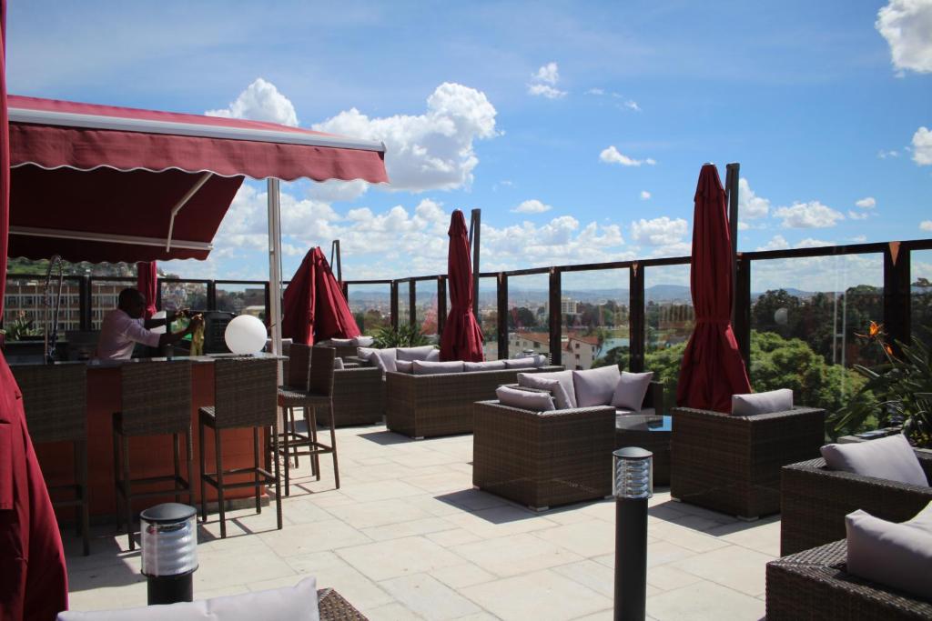 a patio with couches and a bar with a view at Havana Resort in Antananarivo