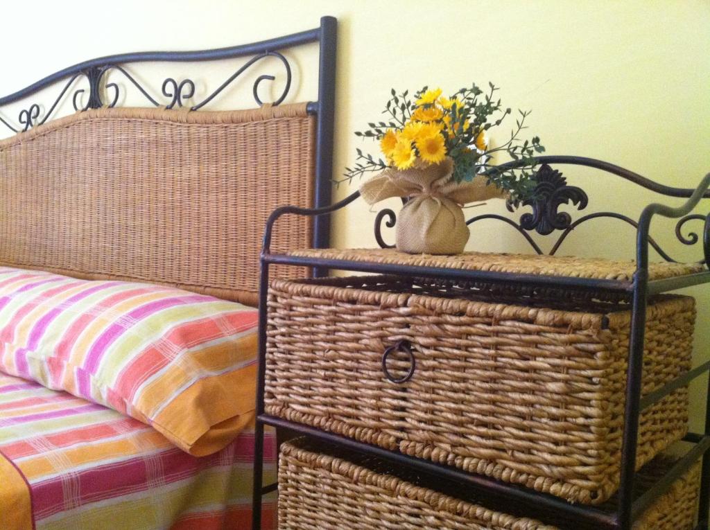 a bedroom with a wicker bed with a basket and flowers at El Salat, alojamientos rurales in Guadalest