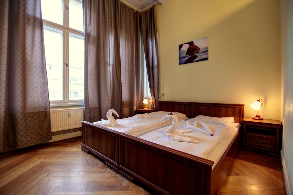 柏林的住宿－選帝侯大街伯恩斯汀潘森酒店，一间卧室配有一张大床,上面有天鹅