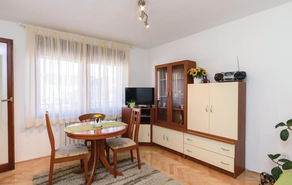 a living room with a table and a tv at Apartman Mira in Daruvar