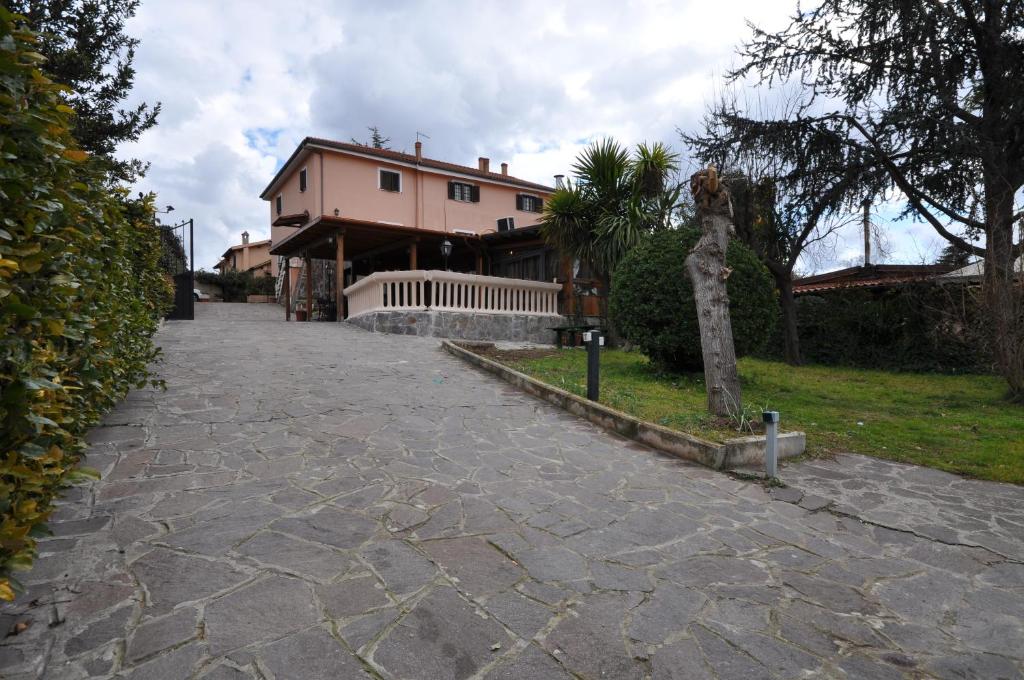 una pasarela de piedra que conduce a una casa grande en Casale De Santis, en Roma