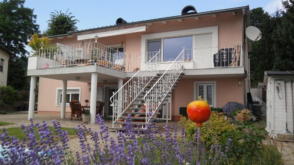 ein Haus mit einer Treppe und Blumen davor in der Unterkunft Holiday Apartment Krumpendorf in Krumpendorf am Wörthersee