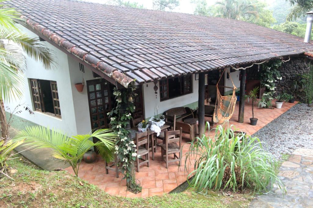 een huis met een tafel en stoelen ervoor bij Pousada das Cavernas in Iporanga