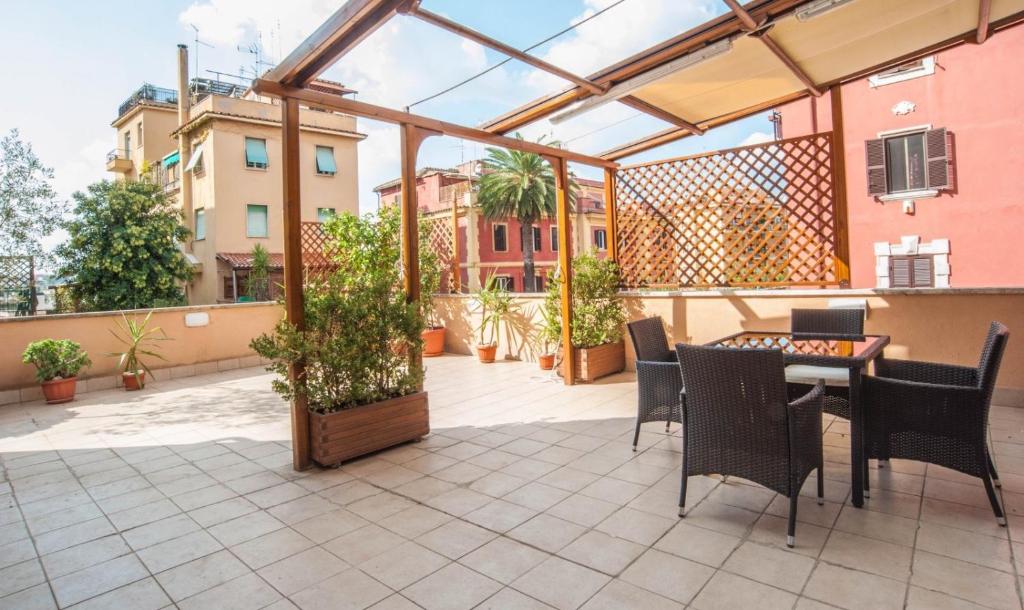 eine Terrasse mit einem Tisch und Stühlen auf dem Balkon in der Unterkunft Terrace99 in Rom
