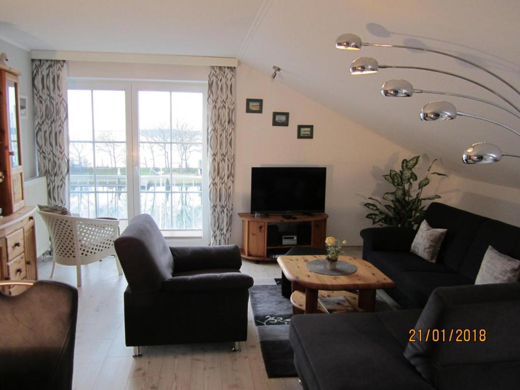 a living room with a couch and a tv at Panoramablick-Orther-Hafen-Fehmarn in Orth
