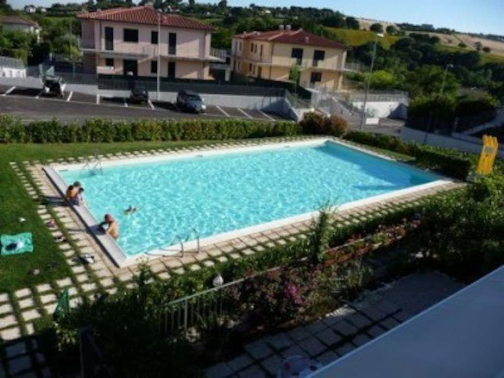 a large blue swimming pool in a yard at Gugliormella in Sirolo
