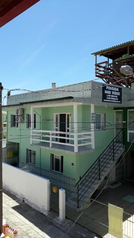 a green building with stairs in front of it at Pousada Mar Verde in Florianópolis