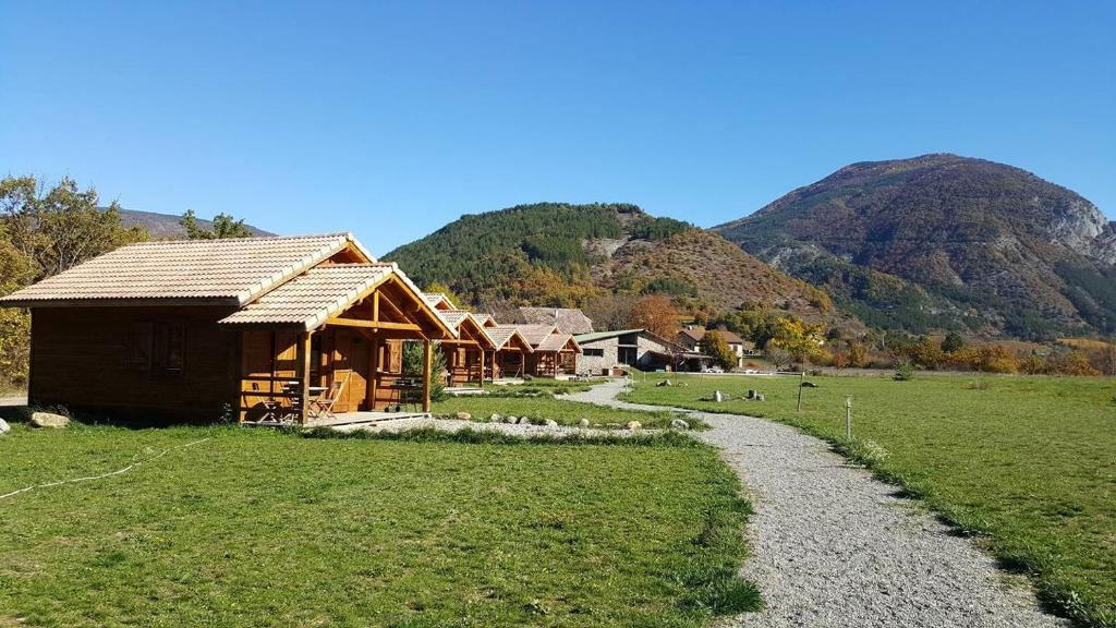 a house in a field with mountains in the background at Domaine De Malcor in Jarjayes