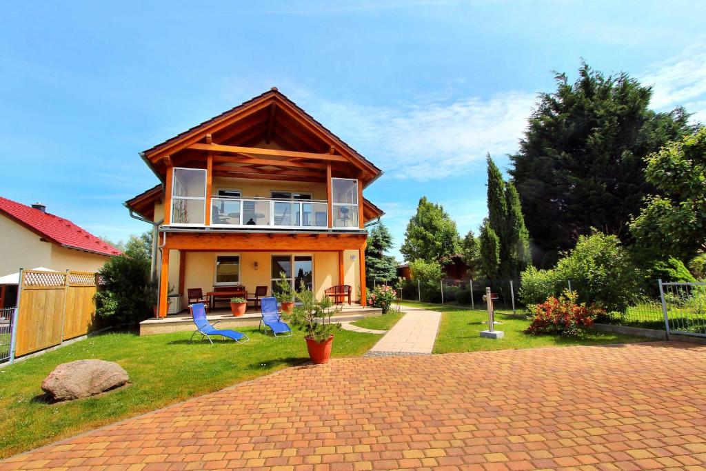 ein Haus mit zwei blauen Stühlen im Hof in der Unterkunft HAUS MÜRITZBRISE / EG-Fewo in Klink