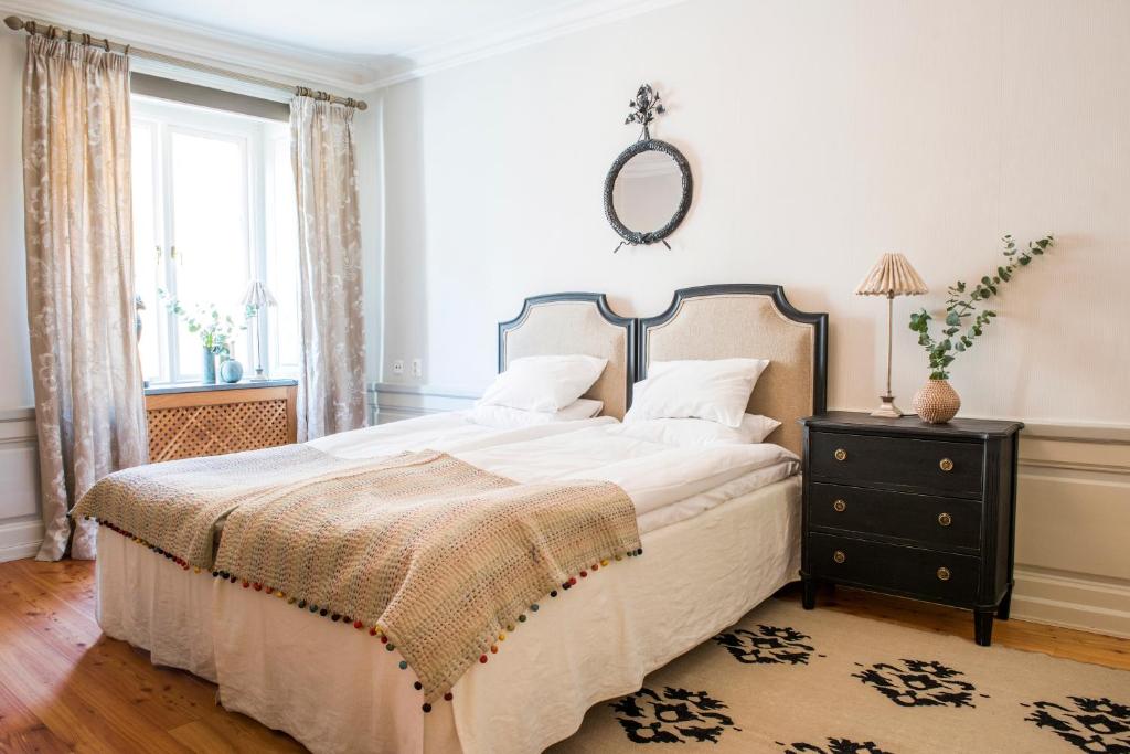 - une chambre avec un grand lit et un miroir dans l'établissement Residence Perseus, à Stockholm