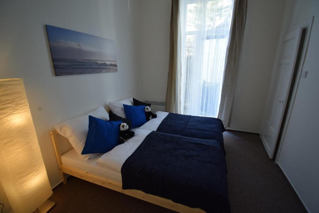 ブルノにあるOllis garden Apartmentのベッドルーム(青い枕の大型ベッド1台付)