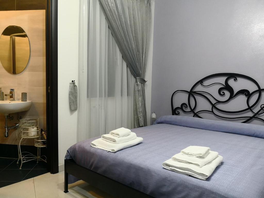 a bedroom with a bed with towels on it at B&B LA CASA DI GIORGIA DI PELLICANO' FRANCESCA in Reggio di Calabria