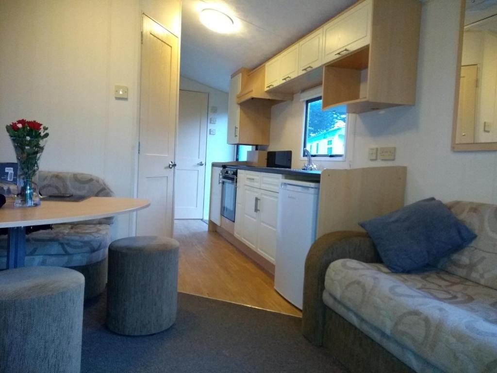 a kitchen and living room with a couch and a table at Newquay View Hideaway in Newquay