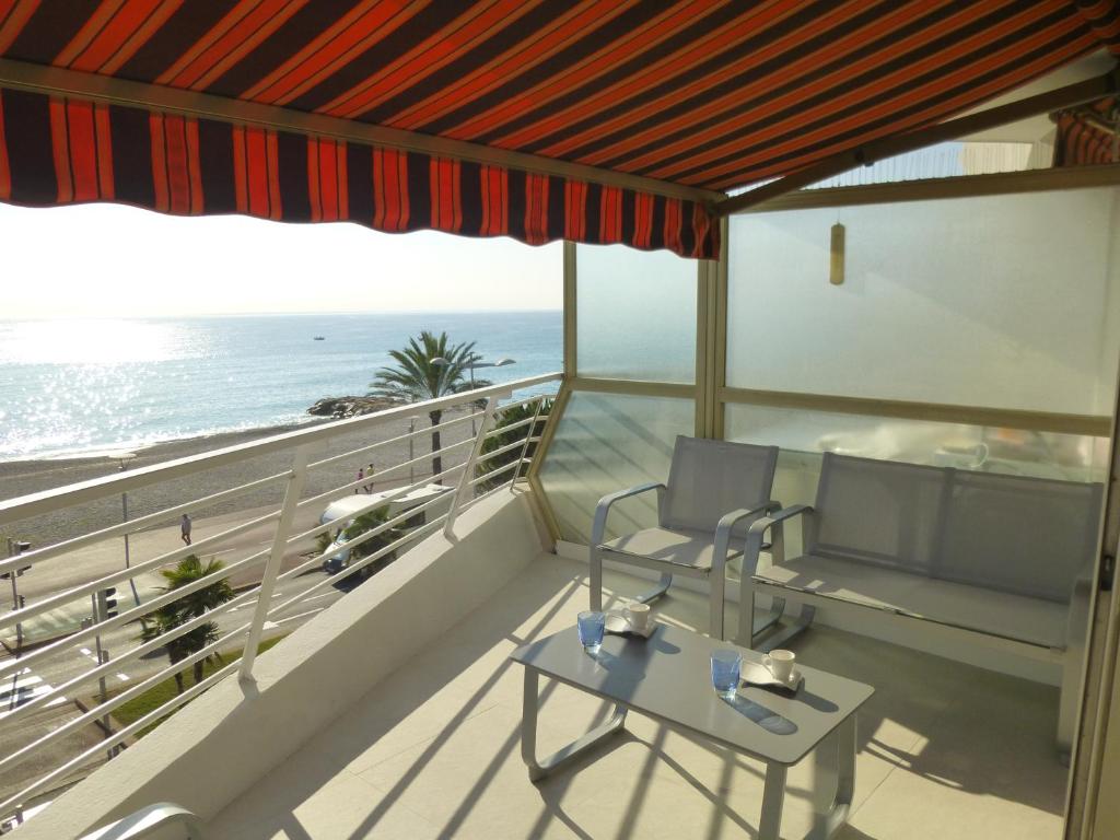 einen Balkon mit einem Tisch, Stühlen und Meerblick in der Unterkunft Appartement Le Chantilly in Cagnes-sur-Mer