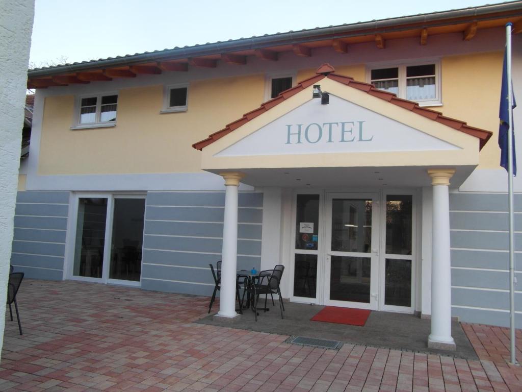 a hotel with chairs and tables outside of it at Hotel Am Donaubogen in Sarching